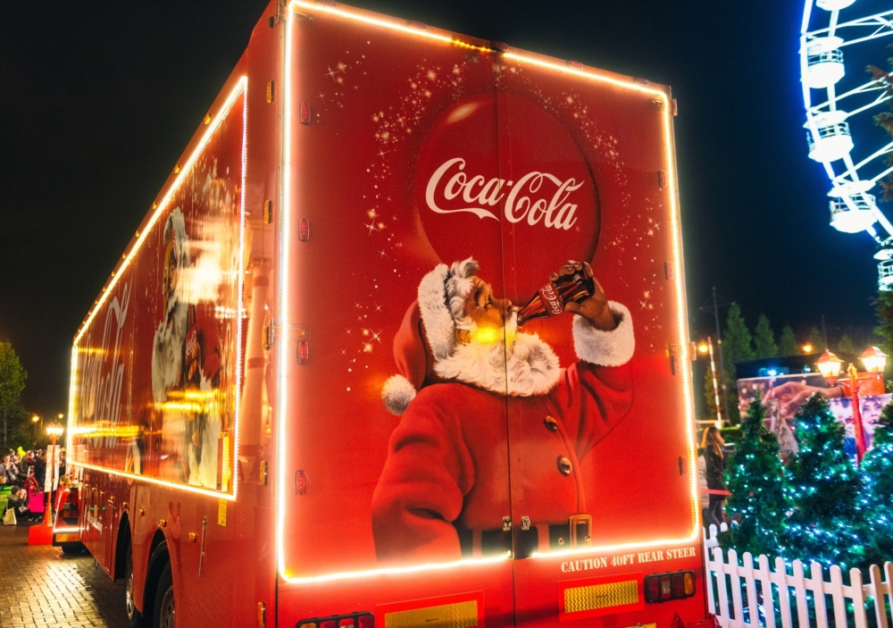 Back of a red truck with lights around the image of Santa drinking Coca-Cola