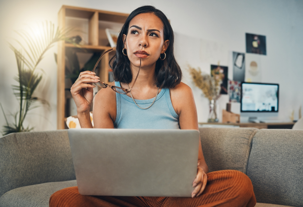 A pensive-looking woman holding a laptop