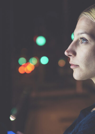 Woman touching a screen at night