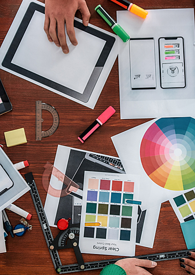 Colourful brand design mockups strewn across a table