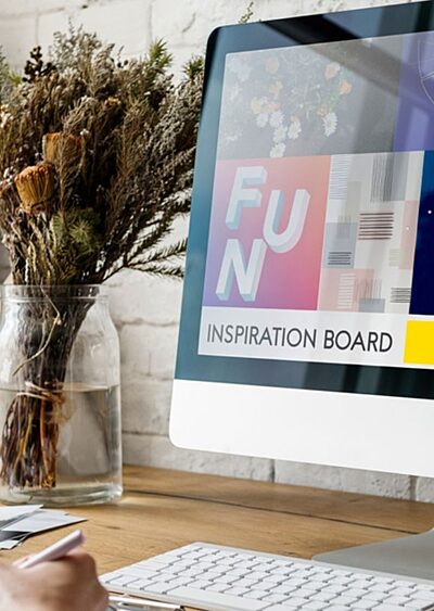 A woman facing a computer monitor with a colourful mood board onscreen