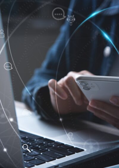 Woman using mobile phone and laptop computer.