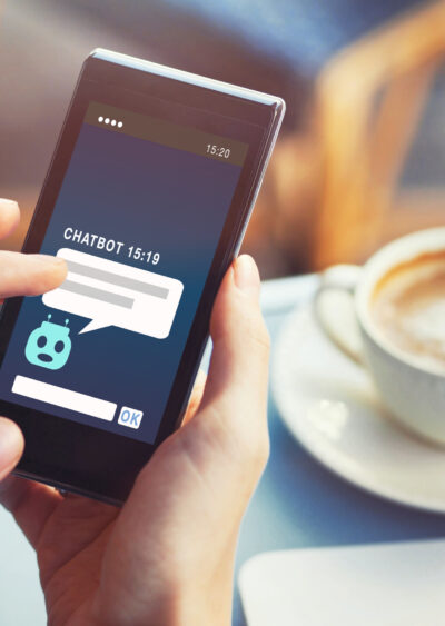 Person on phone with chat bot and a coffee in the background