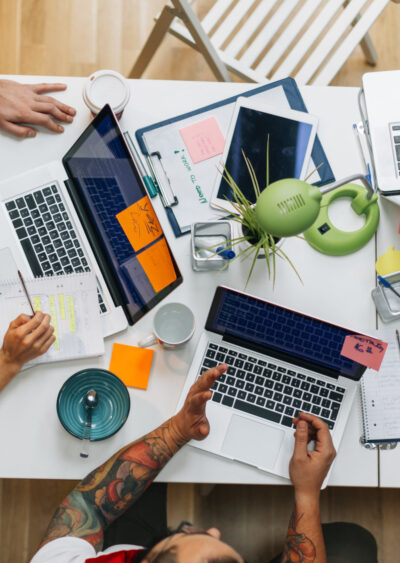 Overhead view of marketing team working at a desk with laptops