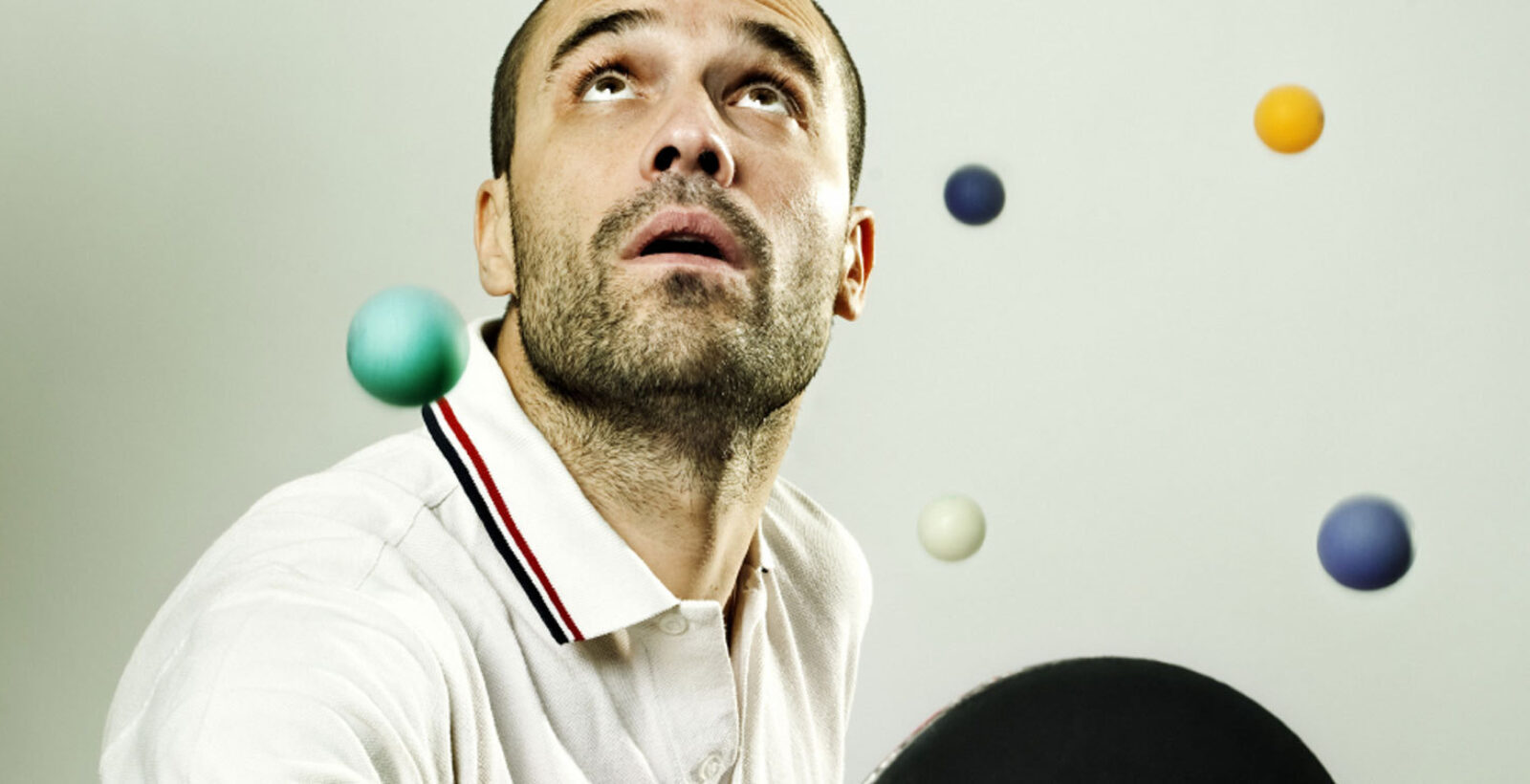 Man looking up with colourful balls in the background