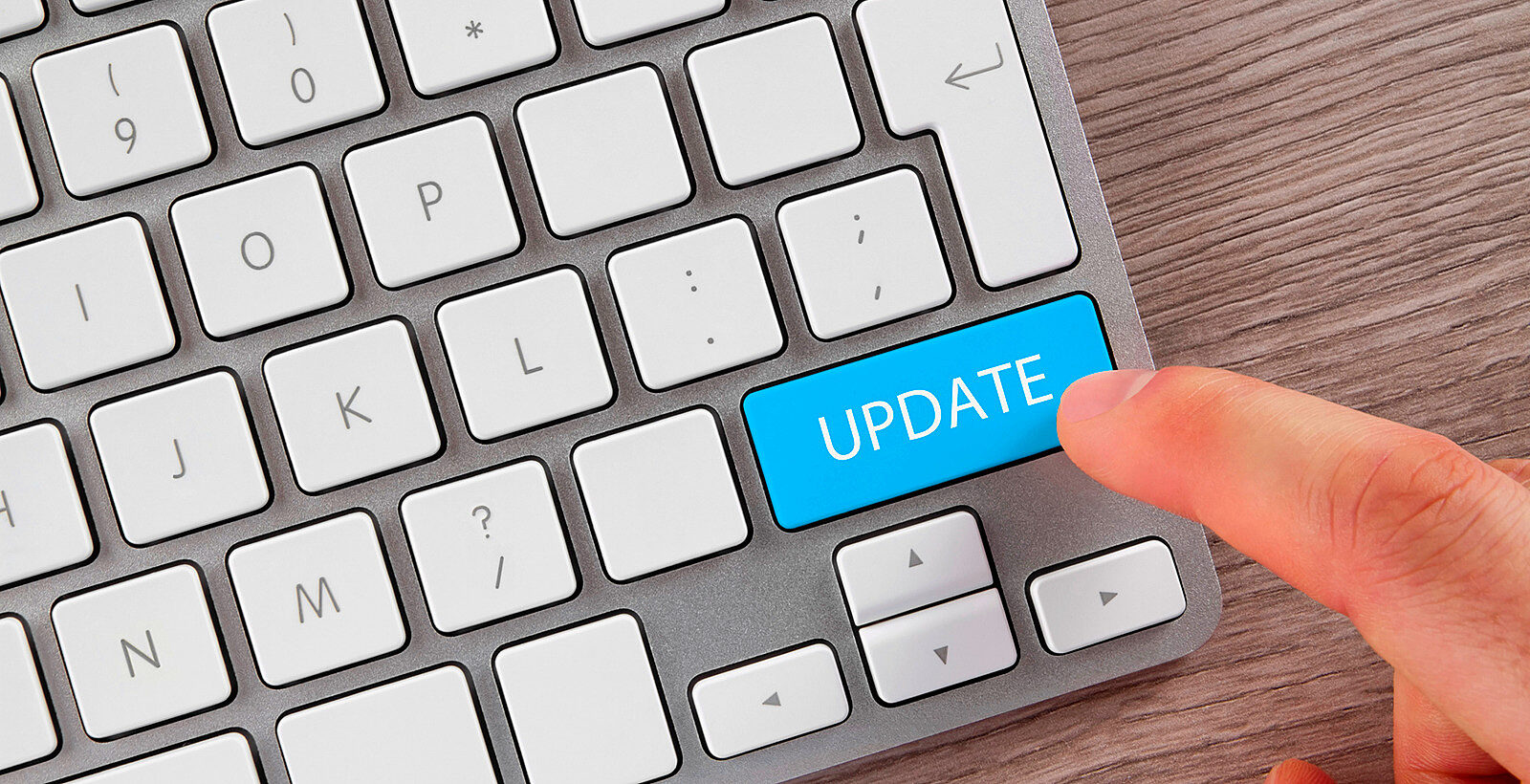 A keyboard with someone's finger hovering over the word UPDATE