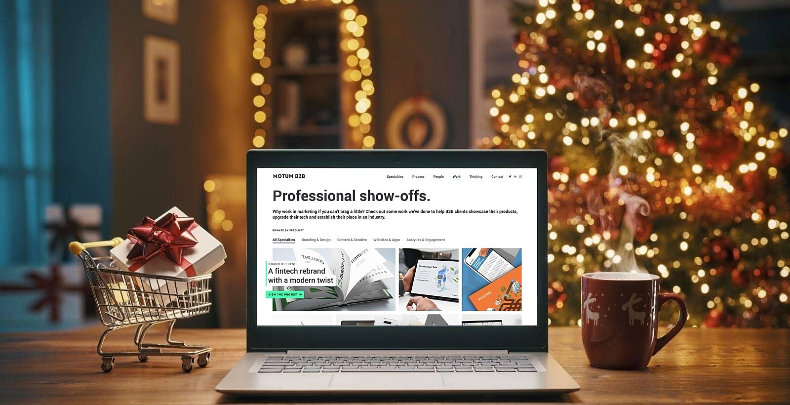 Laptop with festive tree and holiday shopping cart