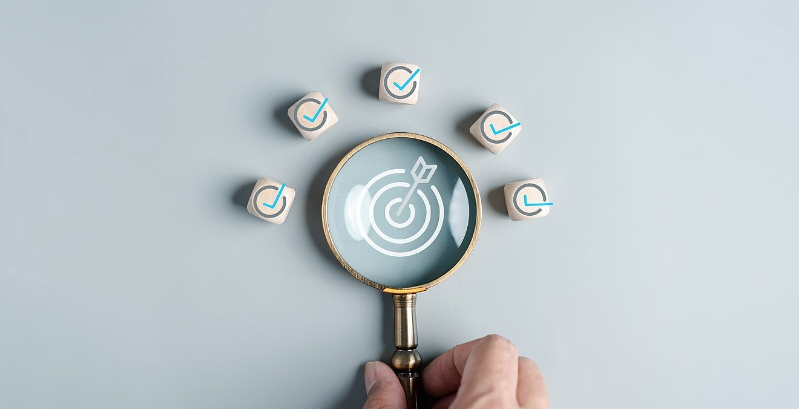 A magnifying glass with a bullseye and arrow in the centre, surrounded by tick icons.