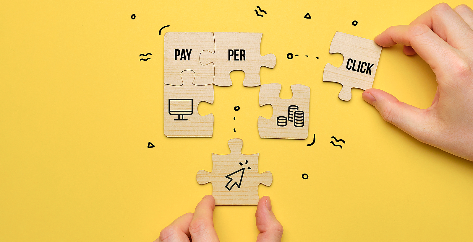 Hands putting together puzzle pieces that say "pay-per-click"