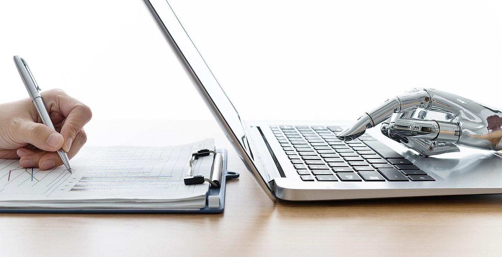 Robot hand using laptop and man hand writing